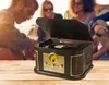 People are gathered outdoors, possibly at a beach, with a retro record player in the foreground. Produktbild-Vorschau