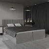 A modern bedroom with a large grey upholstered bed. Produktbild-Vorschau