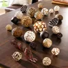A collection of decorative balls made from natural materials arranged on a wooden table. Produktbild-Vorschau