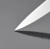 A close-up shot of the tip of a knife blade casting a shadow on a reflective gray surface. Anteprima dell’immagine prodotto
