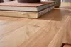 Detailaufnahme der naturbelassenen Akazie-Holzoberfläche des Couchtisch Mumbai 110cm mit sichtbarer Holzmaserung. Voir les images du produit