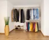 A corner of a room with a clothing rack system and a decorative plant. Produktbild-Vorschau
