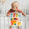 A baby is playing with a colorful interactive toy board attached to a crib. Podgląd zdjęcia produktu