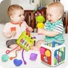Two babies are playing with educational toys on a bed. Produktbild-Vorschau