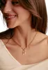 Close-up of a woman wearing a gold necklace with a key charm and a pearl. Anteprima dell’immagine prodotto