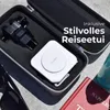 A travel power bank and accessories are neatly arranged in a travel case, with a book and sunglasses nearby. Produktbild-Vorschau