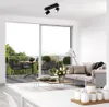 A modern living room with a balcony view, featuring a sofa, coffee table, and dining set on the balcony. Produktbild-Vorschau
