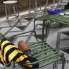 An outdoor seating area with a table and chairs, featuring a patterned rug. Produktbild-Vorschau