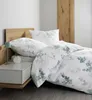 A neatly made bed with floral patterned bedding. Produktbild-Vorschau