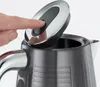 A close-up shot of a person's finger pressing a button on the lid of a kettle. Anteprima dell’immagine prodotto
