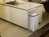 A modern kitchen island with a sink and cabinets, with a stainless steel trash can placed next to it. Podgląd zdjęcia produktu