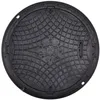 A black manhole cover with a textured surface and embossed markings. Produktbild-Vorschau