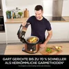 A man is demonstrating a multi-cooker in a kitchen setting. Produktbild-Vorschau