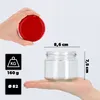 A hand holds a red lid above a glass jar, with dimensions and weight information displayed. Náhľad obrázku produktu