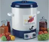 A juice maker and canning pot is shown on a table with various fruits, bottles of juice, and jars of preserved fruit. Náhled obrázku produktu