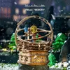 A wooden orrery model with colorful spheres, set in a snowy, outdoor scene with blurred trees and lights in the background. Voir les images du produit