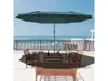 A patio set with a large umbrella overlooking the ocean. Náhled obrázku produktu