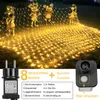 A net of warm white fairy lights draped over grass with golden cartoon-like figures. Produktbild-Vorschau