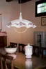 A dining room with a chandelier hanging over a wooden table. Náhled obrázku produktu
