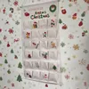 A hanging Christmas advent calendar with 24 pockets, decorated with festive Christmas motifs, against a background of Christmas-themed wallpaper. Anteprima dell’immagine prodotto