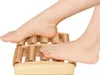 A person's feet are shown using a wooden foot massager. Náhľad obrázku produktu
