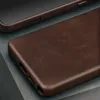 A close-up view of a dark brown leather phone case, showing its texture and branding. Anteprima dell’immagine prodotto