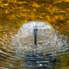 A close-up shot of a water fountain in a pond. Produktbild-Vorschau