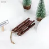 A miniature wooden sled is placed on a snowy surface, surrounded by small artificial Christmas trees and large white mounds that resemble snowdrifts. A small sign with the text "ORDPOL" is visible. Produktbild-Vorschau