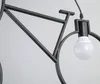 A close-up of a black bicycle-shaped pendant light with a white light bulb. Podgląd zdjęcia produktu