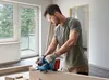 A man is using a Bosch professional cordless planer in a room under renovation. Podgląd zdjęcia produktu