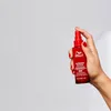 A hand holding a red bottle of Wella Professionals Ultimate Repair Miracle Hair Rescue. Náhľad obrázku produktu