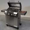 A stainless steel gas grill with the lid open, shown in a neutral indoor setting. Produktbild-Vorschau
