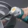 A gloved hand holding a power tool and using it on a metallic surface. Podgląd zdjęcia produktu