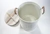 A white metal laundry basket with a wooden lid and rope handles, shown on a white background. Náhled obrázku produktu