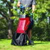 A person is using a garden shredder in a grassy outdoor area with trees in the background. Voir les images du produit