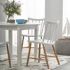 A dining table with chairs in a bright, airy room with a sailboat decoration in the background. Náhľad obrázku produktu