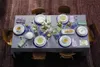 A formal dining table setting with plates, cutlery, glasses, and floral arrangements. Produktbild-Vorschau