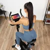 A woman is exercising on a stationary bike in a room. Náhľad obrázku produktu