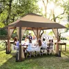 A group of people are gathered around a table under a large gazebo in a garden setting, enjoying a meal. Produktbild-Vorschau