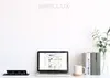 A desk setup with a laptop, a power strip, books, and a plant. Produktbild-Vorschau