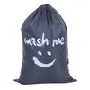 A gray laundry bag with a smiley face and the words 'wash me' printed on it. Produktbild-Vorschau