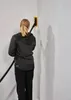 A person is using a sanding tool on a wall corner. Podgląd zdjęcia produktu