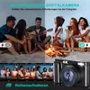 People sitting around a campfire on a beach, with a digital camera in the foreground. Produktbild-Vorschau