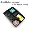 A black drawer organizer filled with office supplies like paper clips, sticky notes, and small dividers. Produktbild-Vorschau