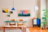 A dining room with a table, chairs, and a large framed TV displaying artwork. Voir les images du produit