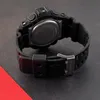 Close-up view of the back of a black digital watch with a metal clasp. Voir les images du produit