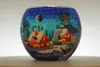 A glass votive holder decorated with a winter village scene. Produktbild-Vorschau
