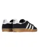 A pair of black Adidas Gazelle sneakers with white stripes and a gum sole, shown from a side-rear angle against a white background. Produktbild-Vorschau