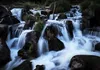 A close-up shot of a waterfall cascading over rocks. Podgląd zdjęcia produktu