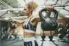 A woman is performing a workout with kettlebells in a gym. Náhled obrázku produktu